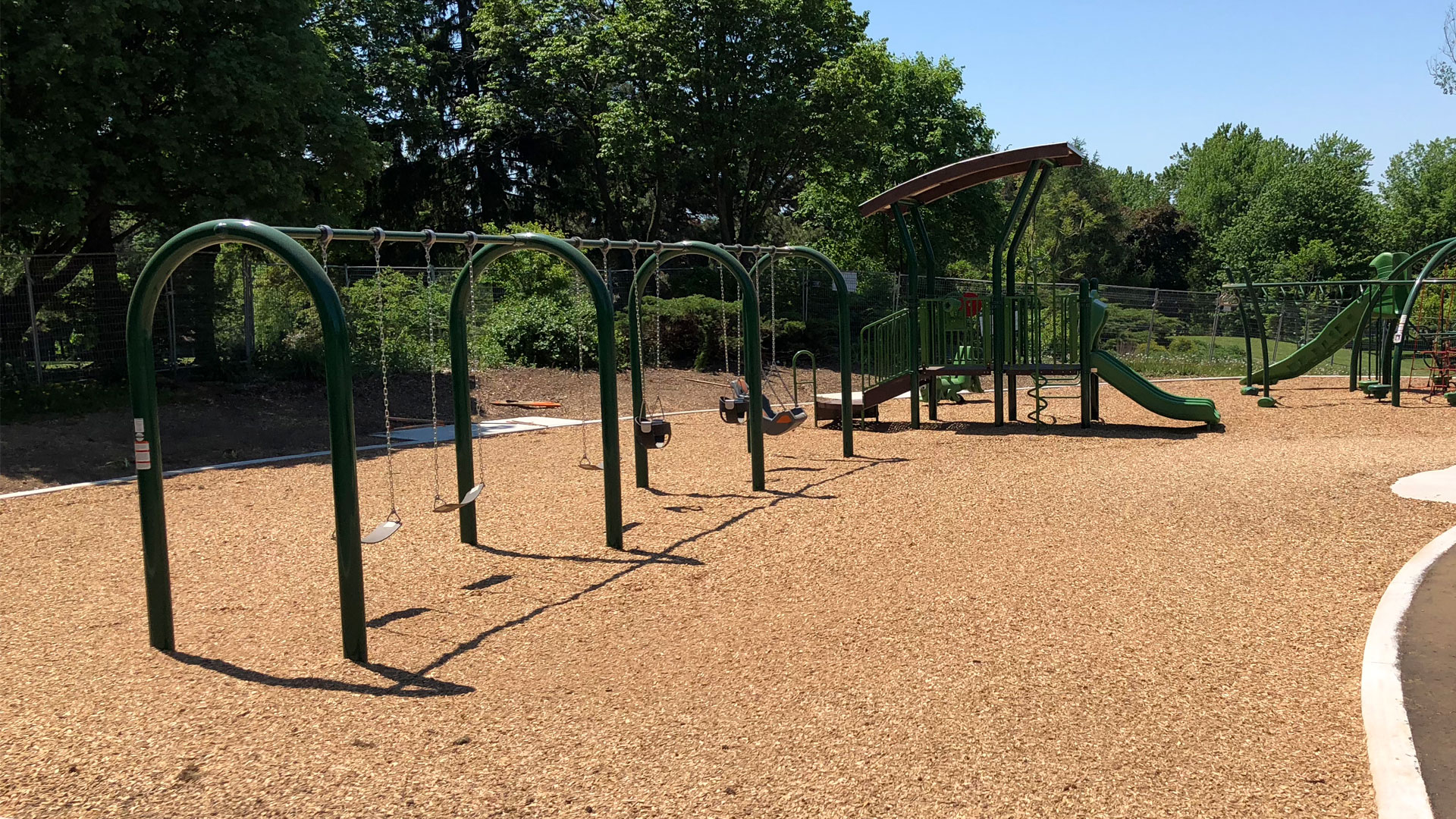 A swing set in playground with Fibertop surfacing
