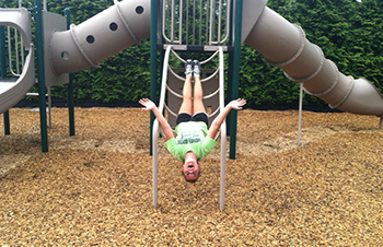 A child plays on playground with Fibertop surfacing